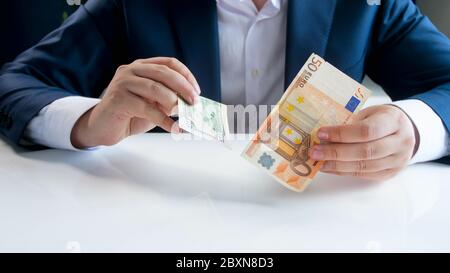 Businesman che detiene banconote in euro e in dollari. Foto Stock