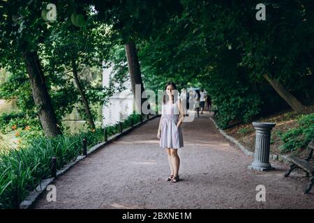 Sofia Park, Uman. Ragazza in una tavola estiva sul vicolo del parco. Bruna sorridente ragazza su un vicolo di pietra vicino al lago. Passeggiata nel parco, un grande bea Foto Stock