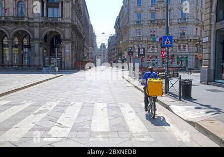 Delivery rider sulle strade vuote del centro di Milano a causa della pandemia del Covid-19, Foto Stock