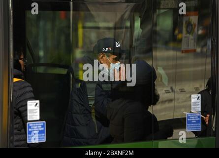 Uomo che indossa la maschera facciale sull'autobus pubblico durante l'emergenza Covid-19, a Milano. Foto Stock