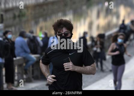 Persone che si fa jogging indossando la maschera durante l'emergenza Covid-19, a Milano. Foto Stock