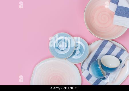 Piatti e ciotole vuoti su sfondo rosa. Vista dall'alto con spazio per la copia Foto Stock