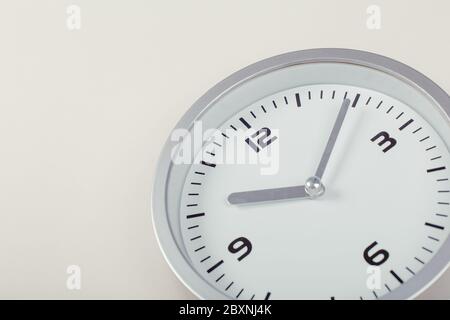 orologio da parete bianco minimalista con metallo chiaro su sfondo beige. concetto di tempo. Foto Stock