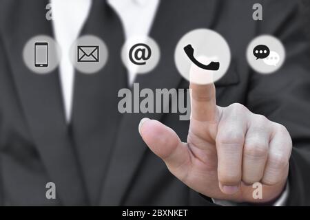 Uomo d'affari premendo icona telefono cellulare, posta, messaggio e indirizzo. Concetto di business Customer Service call center o contattaci. Foto Stock