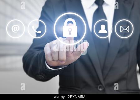 Mano di uomo d'affari premendo il pulsante di sicurezza informatica sullo schermo virtuale. Concetto di sicurezza dei dati personali. Foto Stock