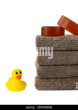 Una pila di asciugamani da bagno e un rubber duck isolata contro uno sfondo bianco Foto Stock