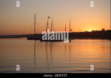 Portogallo, Algarve, Portimao. Barche e barche tradizionali ormeggiate nella Baia di Alvor al tramonto. Alvor è un pittoresco villaggio e località turistica. Foto Stock