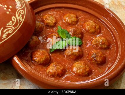 Il Marocco. Kafta tajine - tipici Marocchini e Libanesi piatto di polpette di carne in salsa di pomodoro con la paprika, il cumino, cipolle - cotto in un tagine di argilla. Foto Stock