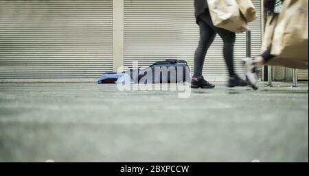 Francoforte, Germania. 6 Giugno 2020. Letto di una persona senza casa sul marciapiede con gambe di persone che camminano. Foto Stock
