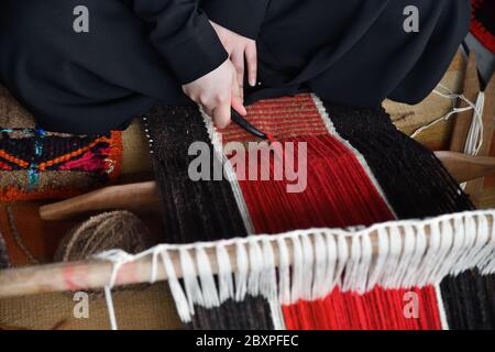 Una donna araba fa una tessitura tradizionale di sadu. Mani di un primo piano tessitore, fuoco sulle mani. Qatar Foto Stock