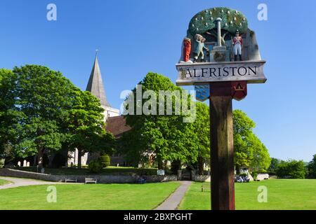 Chiesa di Sant'Andrea e cartello del villaggio, Alfriston, Sussex orientale, Inghilterra, Regno Unito Foto Stock