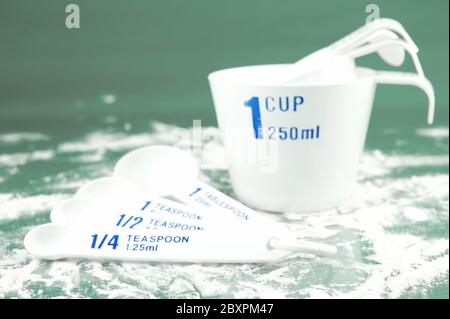 Coppe di misura isolati contro uno sfondo verde Foto Stock