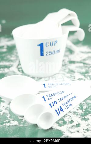 Coppe di misura isolati contro uno sfondo verde Foto Stock