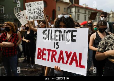 I manifestanti tengono cartelli con slogan che condannano il razzismo. Centinaia di giovani hanno partecipato alla protesta 'Black Lives Matter' a Cracovia, la più grande cit Foto Stock