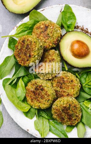 Falafel vegetariano di spinaci all'avocado sul piatto, vista dall'alto. Antipasto arabo medio orientale, meze o pasto sano Foto Stock