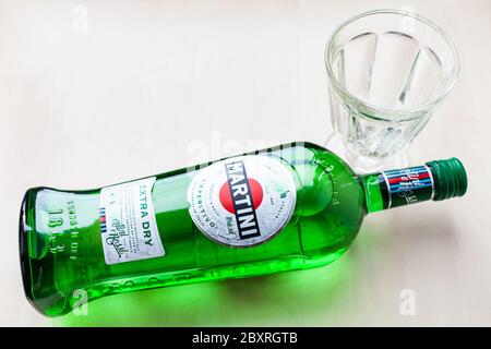 MOSCA, RUSSIA - 23 MAGGIO 2020: Vista dall'alto della bottiglia di Martini Extra Dry e vetro vuoto su tavola marrone chiaro. Martini è il classico vermouth italiano Foto Stock