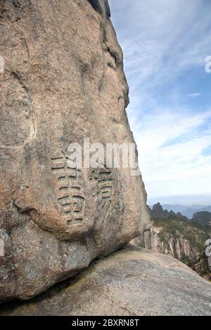 Monte Huangshan nella provincia di Anhui, Cina. Primo piano vista di Flying-Over Rock o Feilai Stone con personaggi cinesi. Foto Stock