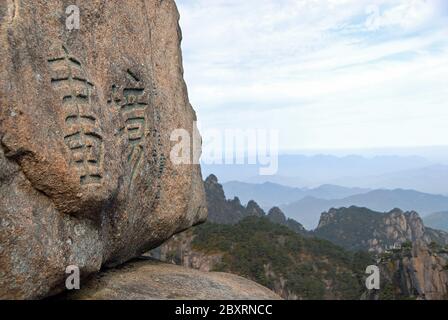 Monte Huangshan nella provincia di Anhui, Cina. Primo piano vista di Flying-Over Rock o Feilai Stone con personaggi cinesi. Foto Stock