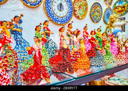 Il negozio turistico offre una grande quantità di souvenir in porcellana, come orologi da parete o figurine di danzatori di flamenco in abiti colorati, Arcos, Spagna Foto Stock