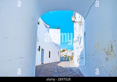 La vista sulla stretta strada curva di Arcos attraverso il piccolo passaggio bianco della porta di Martera, Spagna Foto Stock