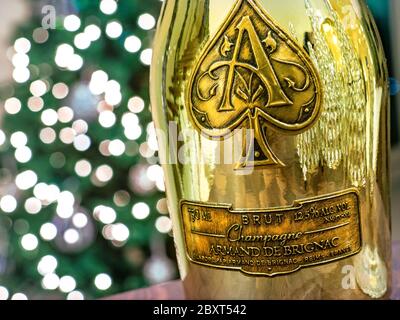 CHAMPAGNE Armand de Brignac ' Ace of Spades'', elegante bottiglia di champagne in oro metallizzato con scintillanti luci di celebrazione dietro Foto Stock