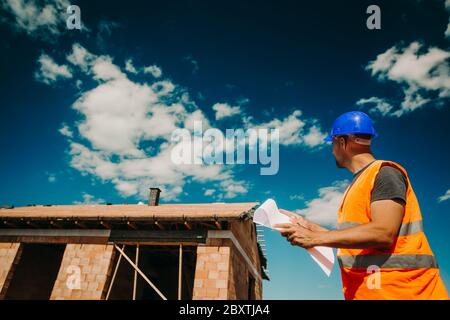 Costruzione, responsabile del sito che sovrintendere alla costruzione del nuovo edificio con un progetto di costruzione, sviluppo di concept Foto Stock