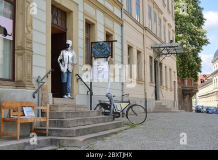 Weimar, Germania 05-19-2020 strada vuota con un negozio di moda con enorme corona maschera all'aperto Foto Stock