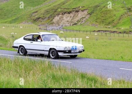 MOFFAT, SCOZIA - 29 GIUGNO 2019: 1985 Ford Capri iniezione auto in un classico rally auto in rotta verso la città di Moffat, Dumfries e Galloway Foto Stock