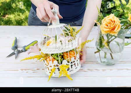 Fiorista al lavoro: Come fare il centro del tavolo moderno per il matrimonio estivo. Molta vegetazione essendo composta in una sistemazione stupefacente. Passo dopo passo, Foto Stock