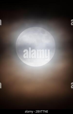 Luna piena di fragole attraverso le nuvole sulle Montagne Rocciose, Salida, Colorado, Stati Uniti Foto Stock