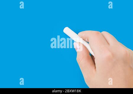Mano con chalk scrivere sulla lavagna Foto Stock