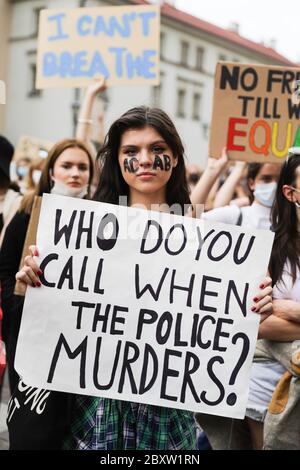 Cracovia, Polonia minore, Polonia. 7 Giugno 2020. Una giovane donna protesteria con l'abbreviazione 'ACAB' dipinta sul viso, tiene un cartello con uno slogan 'Chi chiami quando la polizia ometta?' Durante la protesta Black Lives Matter centinaia di giovani hanno partecipato alla protesta Black Lives Matter a Cracovia, la più grande città della Polonia meridionale. Hanno reso omaggio a George Floyd ed hanno espresso la loro disapprovazione per la brutalità e il razzismo della polizia. Credit: Filip Radwanski/SOPA Images/ZUMA Wire/Alamy Live News Foto Stock