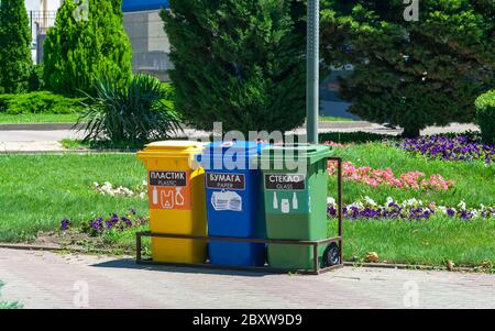 Tre contenitori per il riciclaggio di vetro, plastica e carta su una strada cittadina Foto Stock