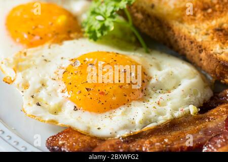 Uova di Sunnyside fatte in casa prima colazione con toast e pancetta Foto Stock