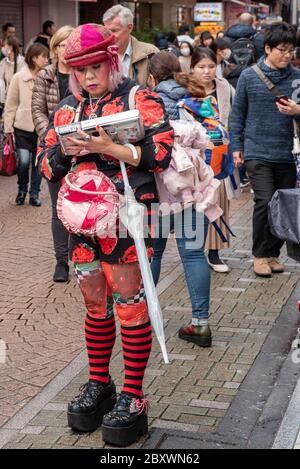 Un teen giapponese che indossa abiti contemporanei e cappello che cammina su Takeshita Street, il centro della moda di Harajuku a Tokyo Foto Stock