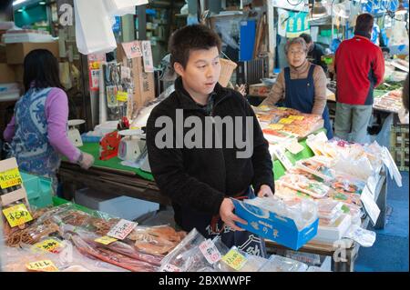 Un fornitore al mercato di Ameyoko a Tokyo, Giappone, offre pesce secco agli acquirenti Foto Stock