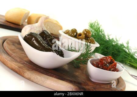 Olive, foglie di vite ripiene e pomodori secchi Foto Stock