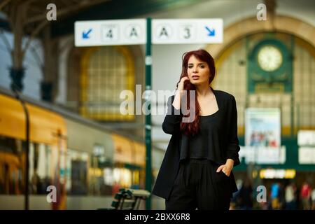 Una donna portoghese attende nella stazione ferroviaria di São Bento a Porto, in Portogallo Foto Stock