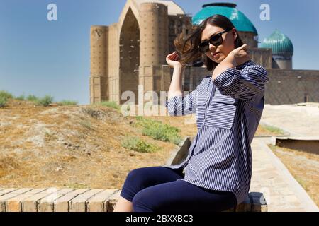 Bella giovane donna asiatica turistica di fronte al Mausoleo di Khoja Ahmed Yasawi. Tour della strada della seta dell'asia centrale Foto Stock