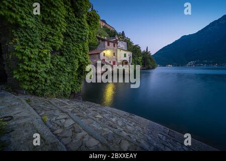 Foto panoramica di nesso sul lago di Como in Italia con primo piano in pietra all'ora blu Foto Stock