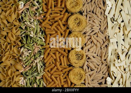 Varietà di tipi e forme di pasta italiana secca. Macaroni italiani fondo o consistenza di cibo crudo: Pasta, spaghetti, pasta a spirale. Foto Stock