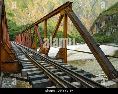 Ponte ferroviario di ferro sul fiume Urubamba che collega Aguas Calientes villaggio vicino Machu Picchu alla stazione di Hydroelectrica, Perù Foto Stock