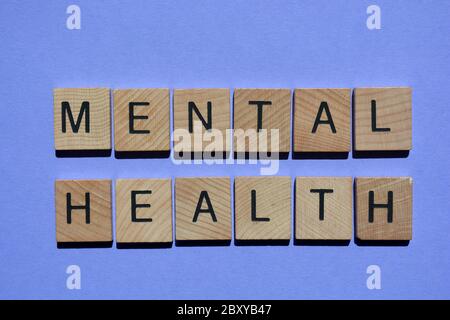 Salute mentale, parole in lettere alfabetiche in legno 3d isolate su sfondo viola Foto Stock