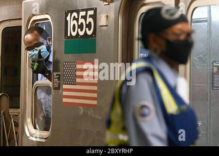 New York City, Stati Uniti. 8 giugno 2020. Una conduzione MTA dà un segno "thumbs up" quando parte dalla stazione di Grand Central 42nd Street, come New York tornano a lavorare utilizzando il transito di massa che un tempo era stato designato solo per i lavoratori essenziali, New York, NY, 8 giugno 2020. Dopo quasi due mesi e mezzo di blocco, nella fase 1 della riapertura, è consentito riprendere la costruzione, la vendita al dettaglio, la produzione e il commercio all'ingrosso, con circa 400,000 persone che torneranno a lavorare dopo due mesi e mezzo di "rifugi-in-place". (Anthony Behar/Sipa USA) Credit: Sipa USA/Alamy Live News Foto Stock