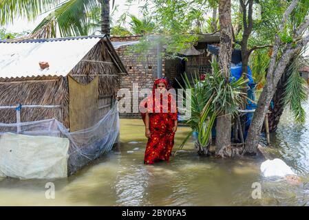 Satkhira, Bangladesh. 5 Giugno 2020. Una donna si trova a casa sua allagata dopo la caduta del ciclone Amphan durante il postmath.migliaia di recinzioni di gamberetti sono stati lavati via, mentre numerosi paglia casa, alberi, elettricità e pali del telefono, I diches e i cropland sono stati danneggiati e molti villaggi sono stati sommersi dall'aumento della marea dell'Amphan nel distretto di Satkhira. Credit: Piyas Biswas/SOPA Images/ZUMA Wire/Alamy Live News Foto Stock