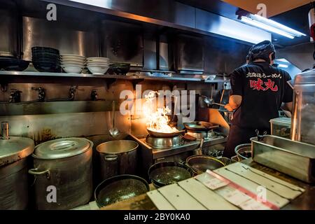 Tokyo Japan 30 Ottobre 2016 : uno chef che prepara un piatto di ramen su un wok fiammeggiante in un piccolo ristorante a Tokyo Japan Foto Stock