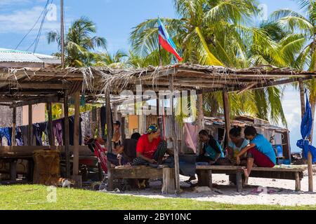 Isola di Mantanani, Sabah, Malesia-CIRCA SETTEMBRE, 2017: Un gruppo di persone locali dell'isola di Mantanani stanno riunendo tagliando un pesce in un piccolo hu Foto Stock