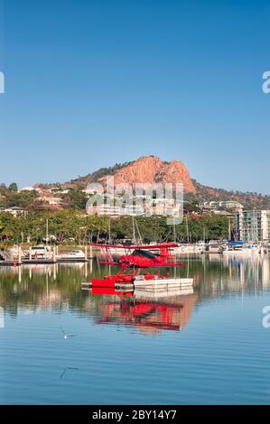 Porto turistico panoramico di Townsville in Australia con artigianato ormeggiato e Castle Hill sullo sfondo e il Red Baron Seaplane ormeggiato in primo piano. Foto Stock