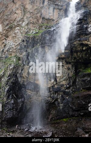 Un uomo locale escursioni sotto la cascata di Belagorka nella valle di Sokuluk del Chuy Oblast del Kirghizistan, vicino Bishkek. Foto Stock