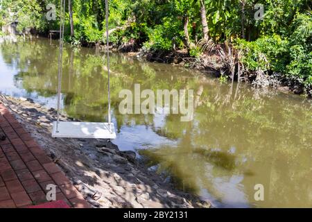 altalena sulla palma vicino al canale Foto Stock